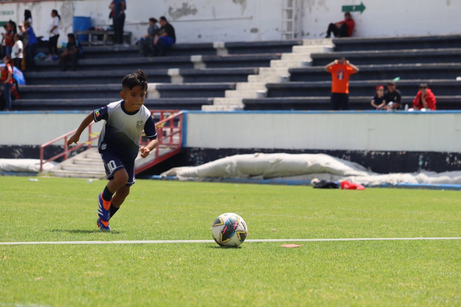 Jugador de fútbol infantil corre hacia el balón durante un partido